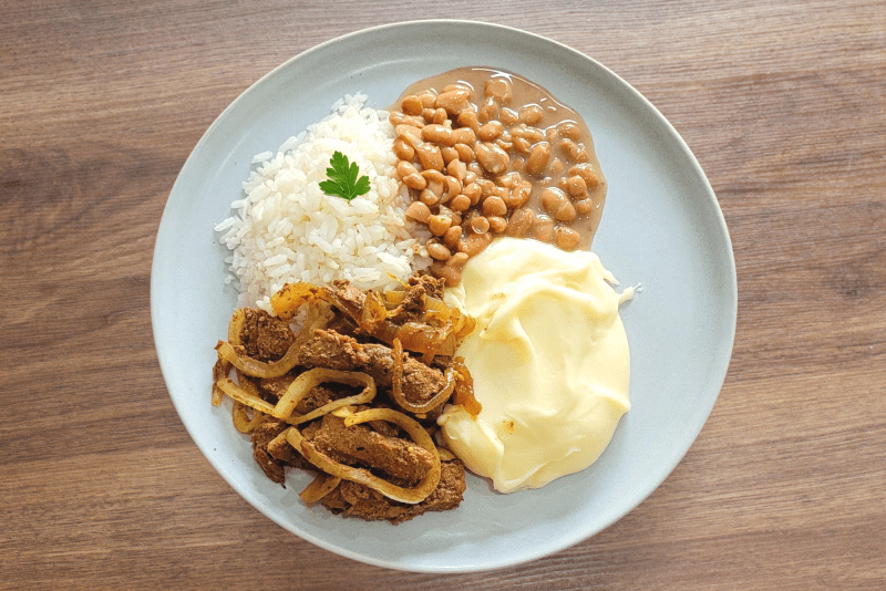 ALCATRA EM TIRAS ACEBOLADA COM ARROZ BRANCO, FEIJÃO E PURÊ DE BATATAS