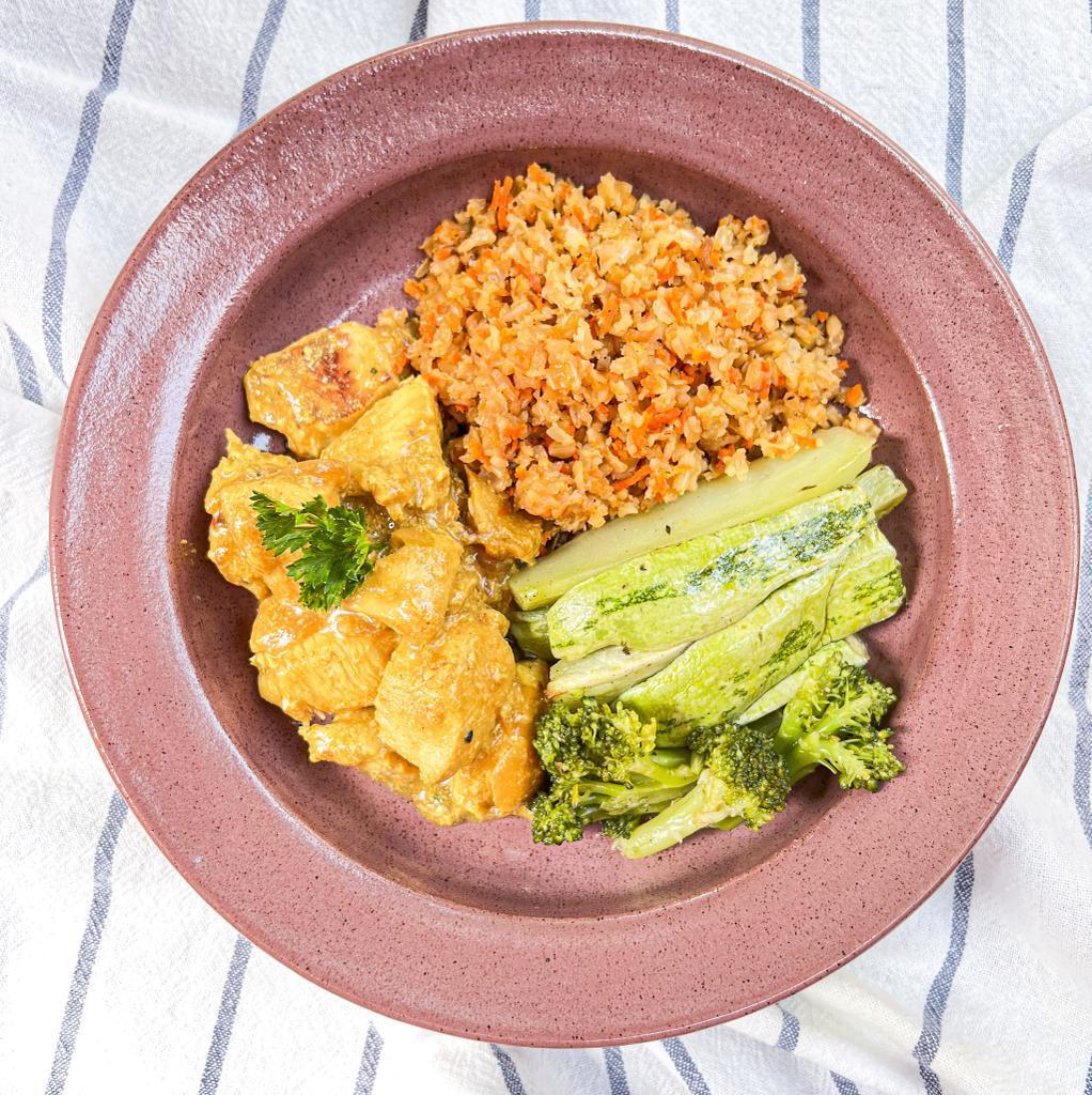 td. Cubos de peito frango marinados em limão e mostarda com cebolas caramelizadas, acompanhado por arroz integral e cenoura, tomate e abóbora ao forno